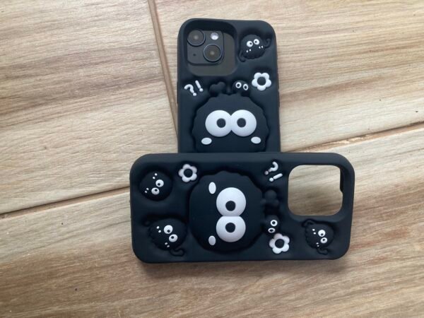 2 Cartoon Black 3D Silicone iPhone 13 Pro Cases on a wooden floor