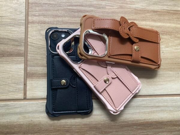 Pink, brown, and black Leather Wristband strap for iPhone 13 Pro on wooden floor