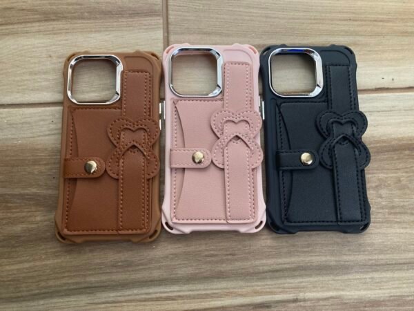 3 iPhone 13 pro cases Pink, brown, and black Leather Wristband strap for iPhone 13 Pro on wooden floor