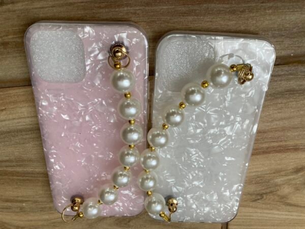 White and Pink Marble iPhone Cases With Bead Pearl Wrist Strap on Wooden Floor